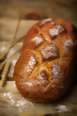 Selective focus. Fresh wheat bread. Flour and ears. Warm toning.