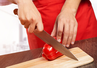 Chef hands cutting red fresh pepper