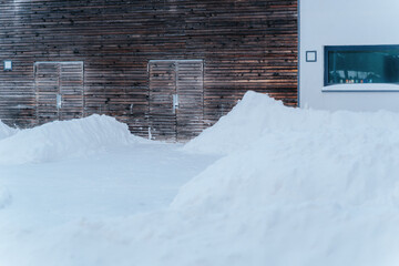 huge piles of snow covering doors and gates of houses