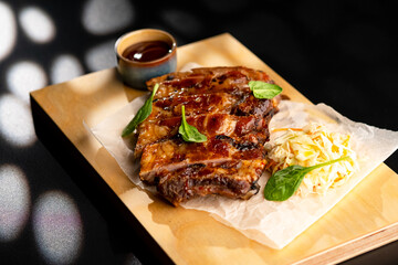 Pork is fried in sauce and sauerkraut, served on a wooden board with sauce.