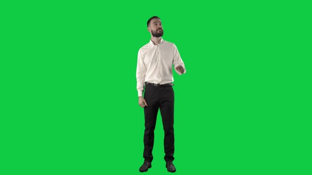 Handsome business man using interactive touch screen gestures. Full length on green screen chroma key background