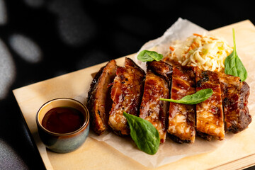 Pork is fried in sauce and sauerkraut, served on a wooden board with sauce.