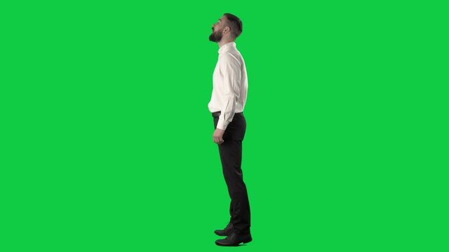 Side view of impatient nervous jumpy business man waiting and standing in queue. Full length on green screen chroma key background