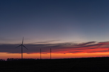 Obraz premium wind generators at sunset, alternative