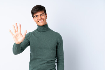 Handsome man over isolated blue background counting five with fingers