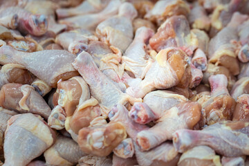 Raw fresh meat of chicken leg (drumstick) selling on local market stall. Raw food and cooking ingredient photo.