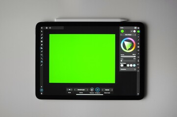 Green background for digital art on tablet. Remote freelance work. Home hobby