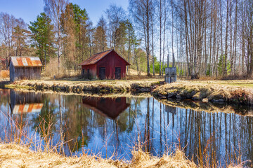Fototapeta premium Idyllic scene near a pond with old buildings somewhere in Sweden.