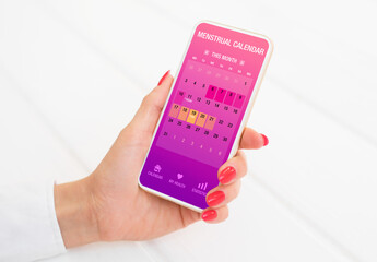 Woman using menstrual calendar app on phone