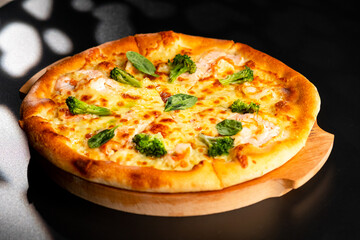 Pizza is not a wooden board. Black background. close-up.