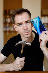 Man with broken phone and hammer.