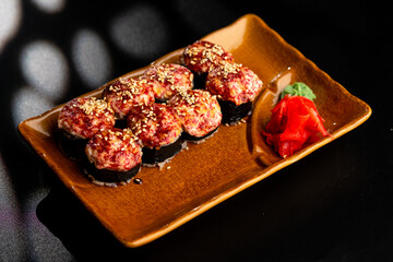 Sushi and rolls, Japanese sea cuisine. Served plates for the restaurant menu on a black background.