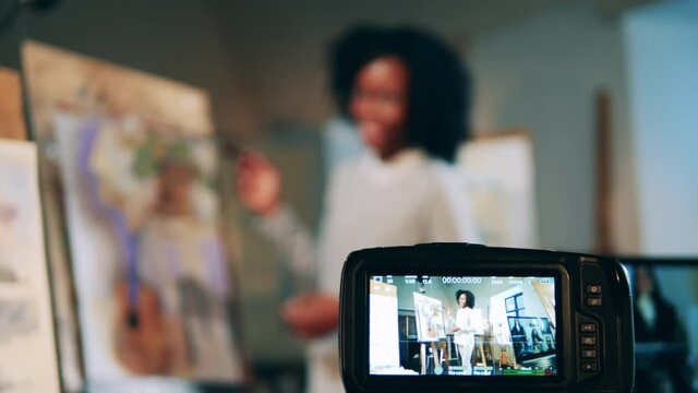 Art lesson of an african lethnicity ady is being filmed on camera