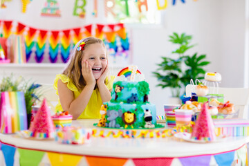 Obraz na płótnie Canvas Child birthday party. Kids blow candle on cake.