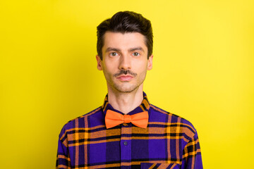 Photo of young handsome man confident serious wear plaid shirt bowtie isolated over yellow color background