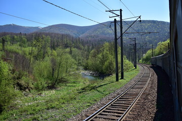 Train and railway line in the 
green scenic mountains