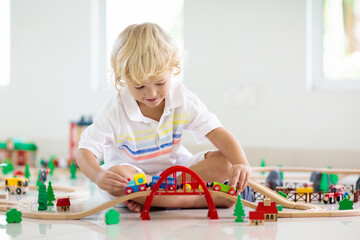 Kids play wooden railway. Child with toy train.