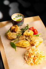 Roasted chicken legs with sauerkraut and sauce. Serving on parchment paper and a wooden board.
