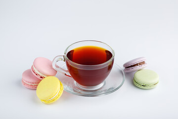 Cup of tea and colorful macaroons on a white background.