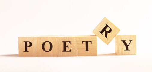 On a light background, wooden cubes with the text POETRY
