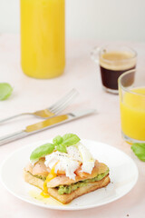 Breakfast with a sandwich with poached egg and avocado