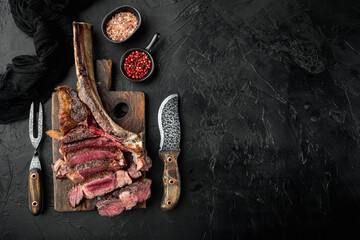 Sliced barbecued tomahawk rib tip with rosemary, salt and herbs medium rare, on wooden serving...