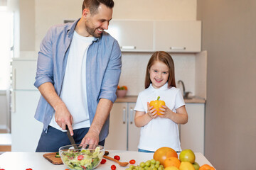 Cute Little Girl And Her Father Preparing Dinner In Kitchen