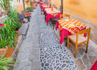 Restaurant tables in a narrow alley in Sardinia