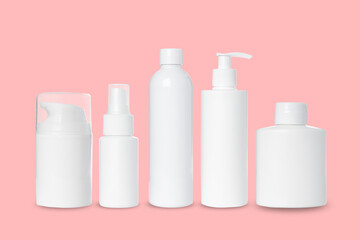 empty white plastic bottles for cosmetics on pink background