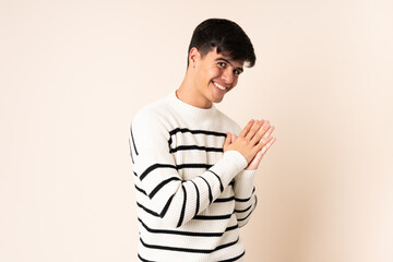 Handsome man over isolated beige background scheming something