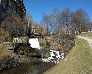 small old house next to a waterfall and a cozy river