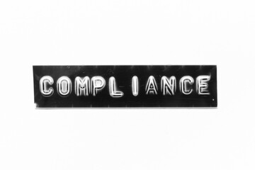 Embossed letter with word compliance in black banner on white paper background