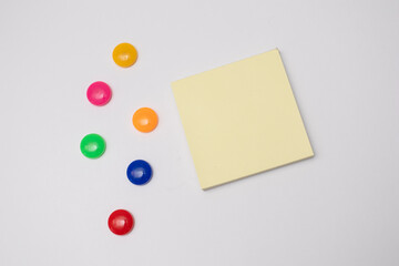 Empty paper sheet on white fridge door and Multicolored stationery magnets. Paper sheet on...