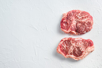 Beef  top blade steak, organic meat. White textured background. Top view with space for text.