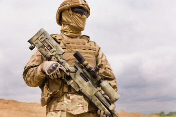 Equipped and armed special forces soldier with sniper rifle, room for text.