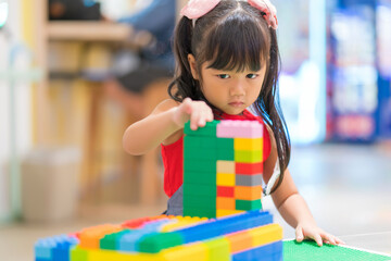 Children play with colorful plastic toys blocks on table