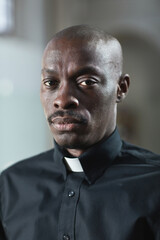 Portrait of African young priest in collar looking at camera