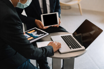 Businessmen team or financial data analysts working with tablets and laptop computers and data graphs. Plan to analyzing projects in the office.