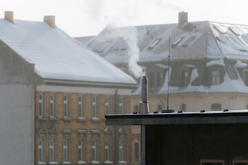 smoke of chimney on rooftop in city