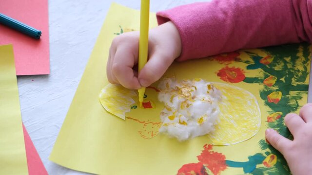 Child making card with Easter chick from colorful paper and cotton pad. Handmade. A project of children's creativity, handicrafts, crafts for kids. 