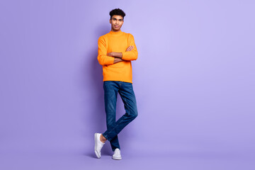 Naklejka premium Full length photo of charming dark skin young confident man hold hands crossed isolated on purple color background