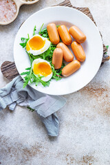 sausages salad poached egg leaves green petals lettuce mix fresh healthy appetizer trend diet meal snack copy space food background rustic. top view keto or paleo diet
