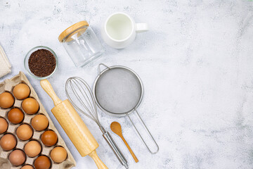 Fototapeta na wymiar Eggs and egg whisks,Top View three eggs in glasses bowl, blurred eggs in wicker basket and egg beater on the floor, preparing preparing for cooking food or dessert, copy space