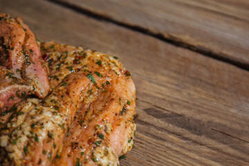 a piece of baked meat on the grill with spices lies on a wooden background close-up. Beautiful delicious fried steak ready to eat