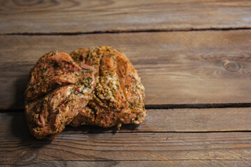 a piece of baked meat on the grill with spices lies on a wooden background close-up. Beautiful...