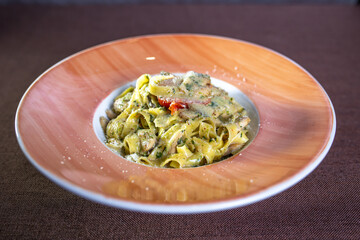 pasta with sauce and tomato on a plate in a restaurant