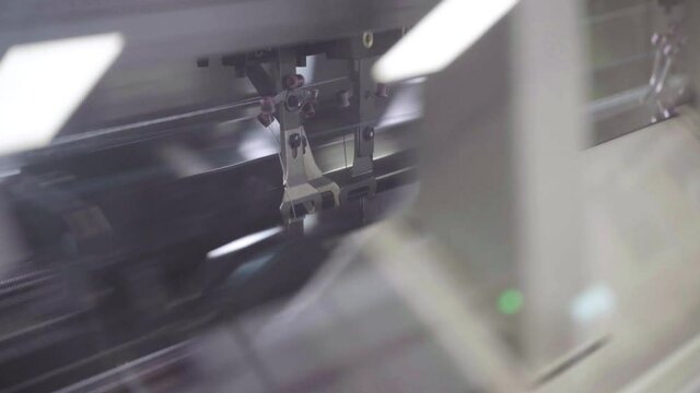 knitting machine moves back and forth to sew clothes, textile industry detail