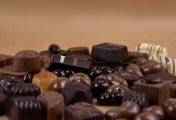Various chocolate pralines on a brown background border stock images. Dark and milk chocolate...
