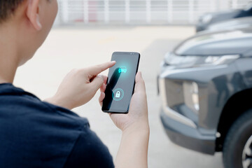 A Man standing next to the car. man using Smartphone near the car. Mobile phone apps for car lock owners concept.