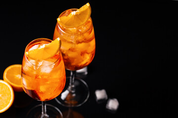 Glasses of ice cold Aperol spritz cocktail served in a wine glass, decorated with slice of orange,...